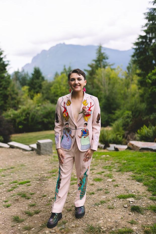 Laine outdoors, full length, embroidered pink suit, mountain behind them